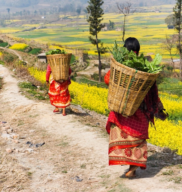Schulkinder sitzen zu einer Feierlichkeit des Nepalschulprojektes auf dem Schulhof.